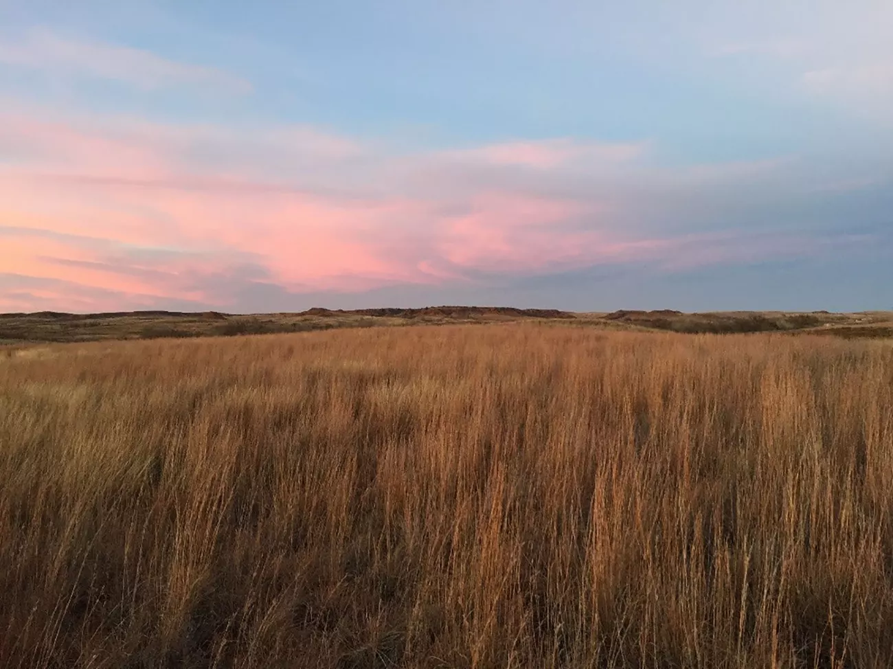 Sun setting over a peaceful field at Washita Battlefield