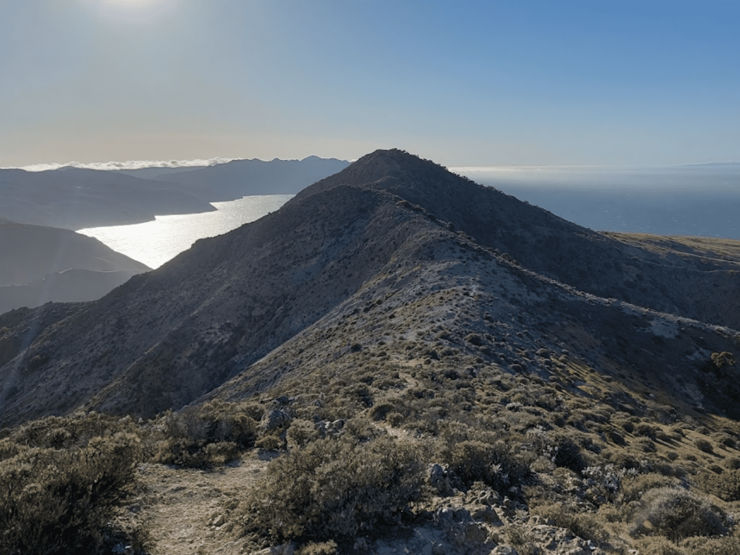 View of the mountains in the foreground in front of a blue ocean, clouds, and sky at Channel Islands National Park.
