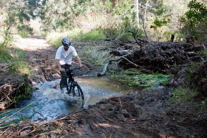 A cyclist rides through a creek at Santa Monica Mountains National Recreation Area in California