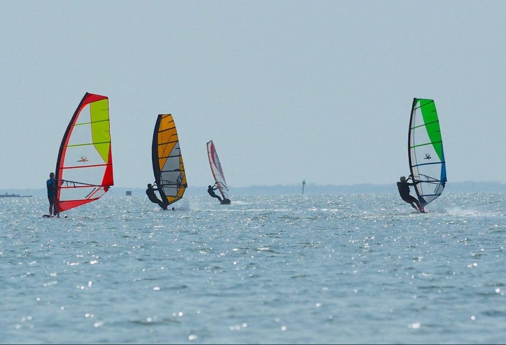 Four colorful windsurfers on the ocean at Padre Island National Seashore