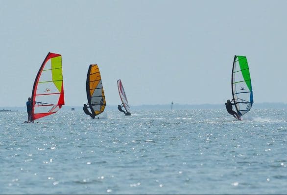 Four colorful windsurfers on the ocean at Padre Island National Seashore