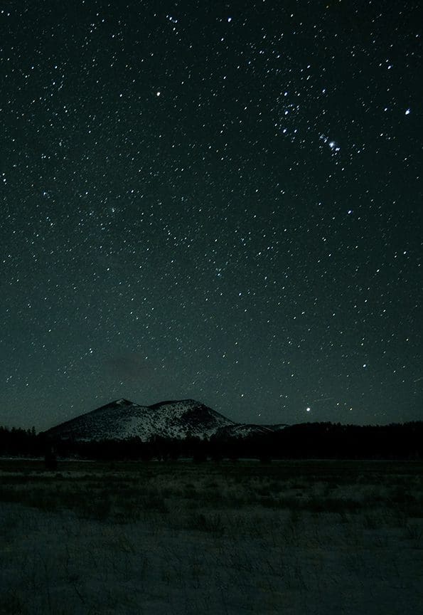 The constellation Orion rises over Sunset Crater Volcano.
