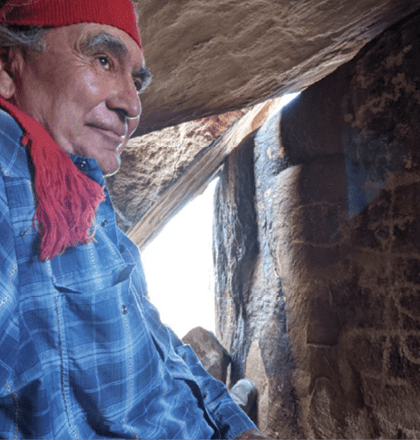Manso descendant Cruz Camargo in rock shelter with petroglyphs (courtesy of Deni Seymour).
