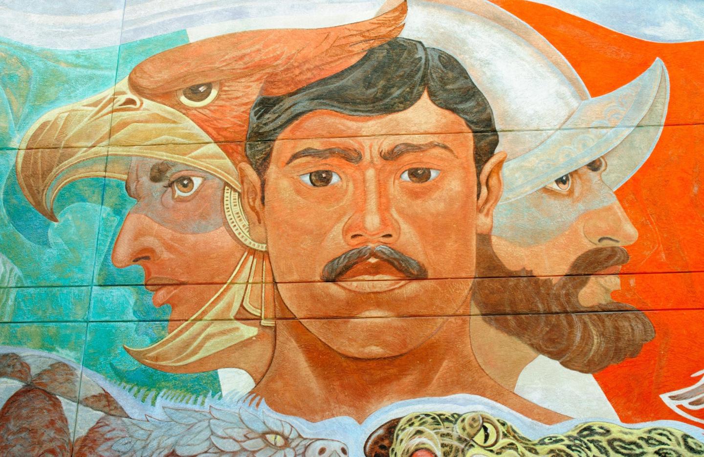 Mural with three stylized faces, including an eagle and a conquistador.