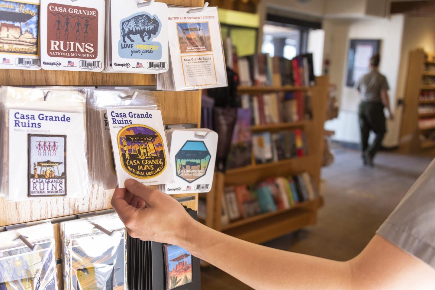 Person holding a souvenir magnet in a gift shop.