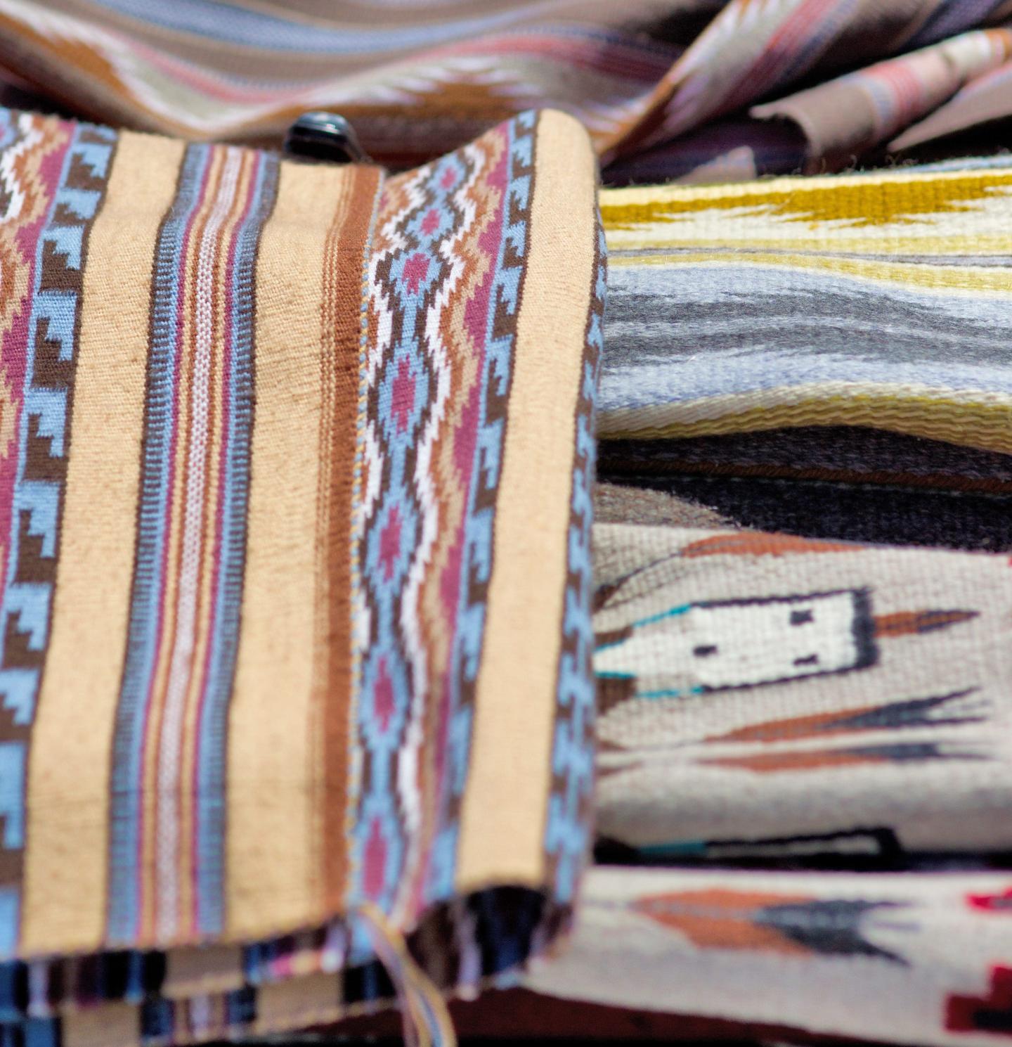 Colorful woven textiles with intricate patterns and stripes.