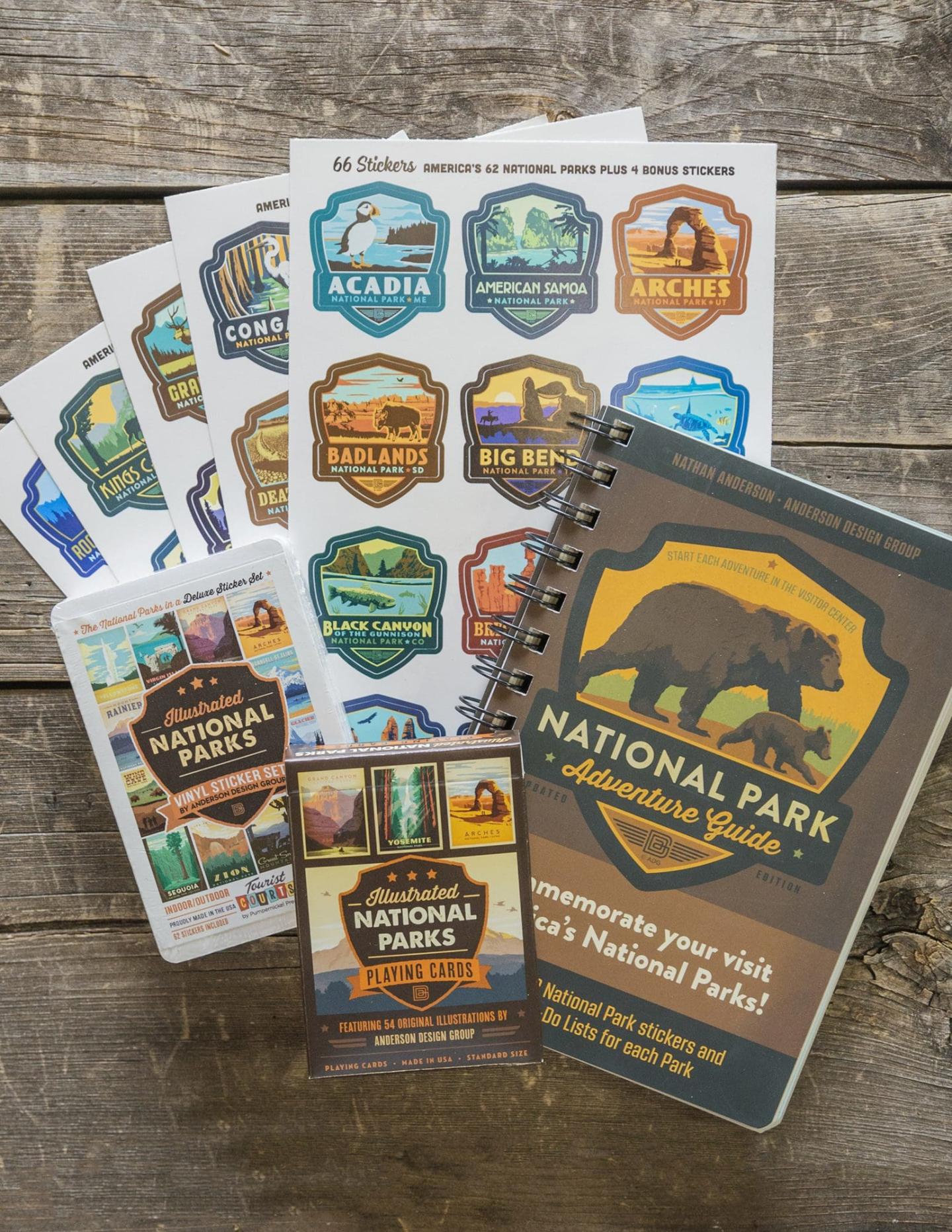 Stickers and a notebook with national park designs on a wooden surface.
