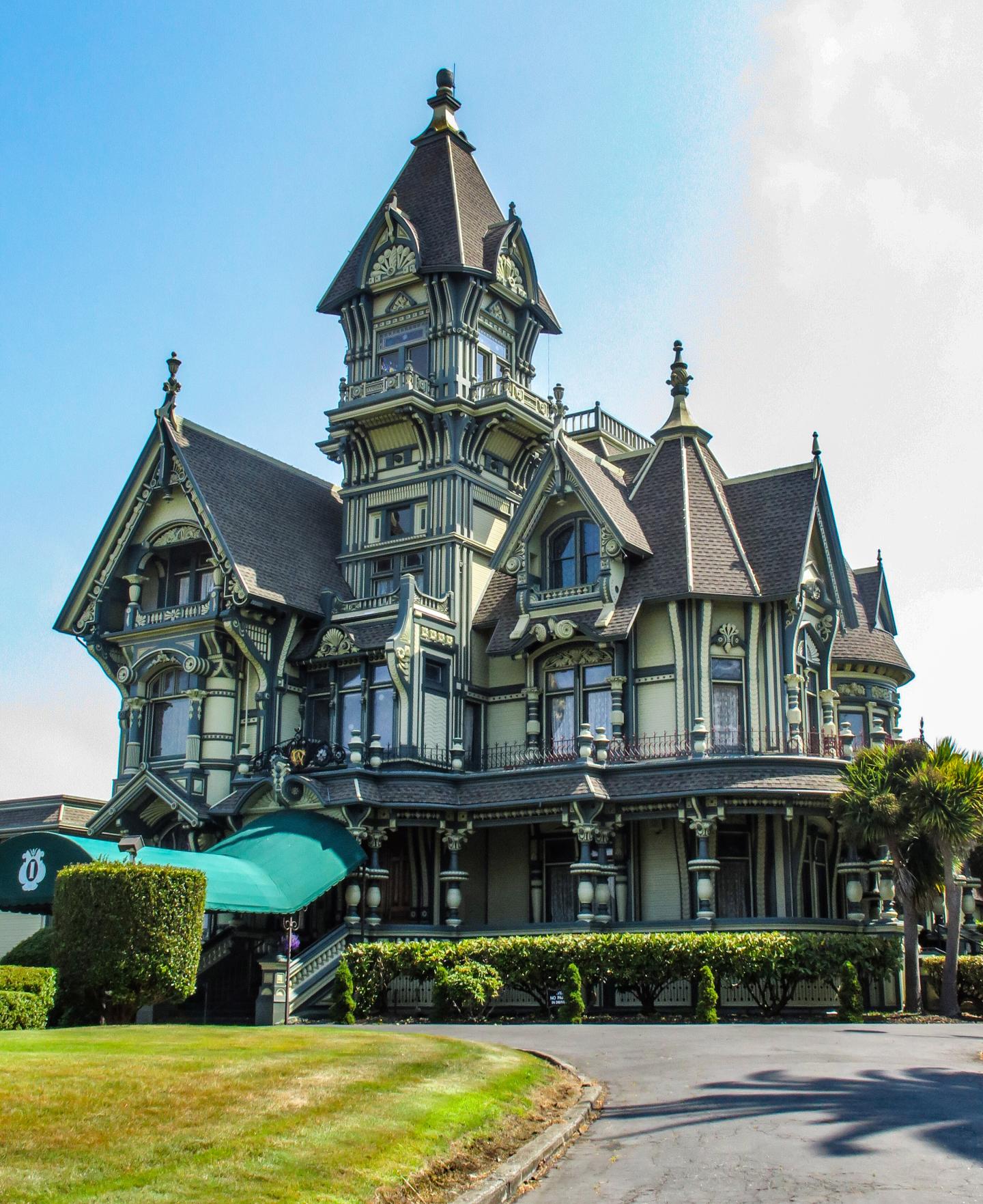 Carson Mansion with intricate details, lush lawn, and clear blue sky.