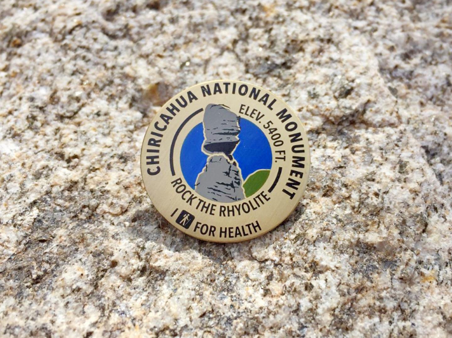 Chiricahua National Monument logo pin on a speckled stone background.