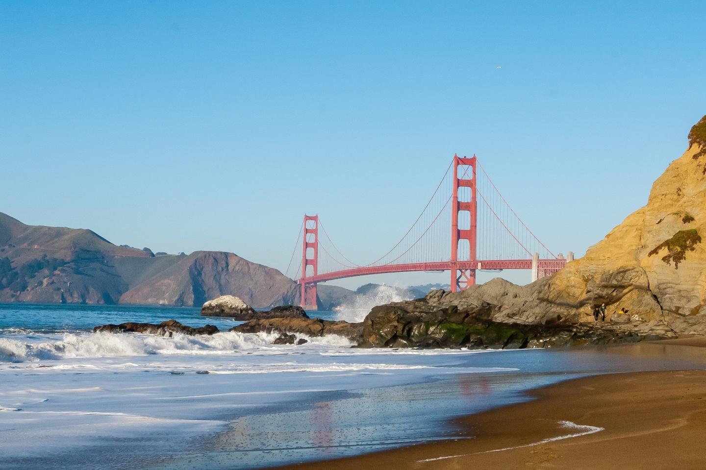 Golden Gate Bridge over a sunny coastline.