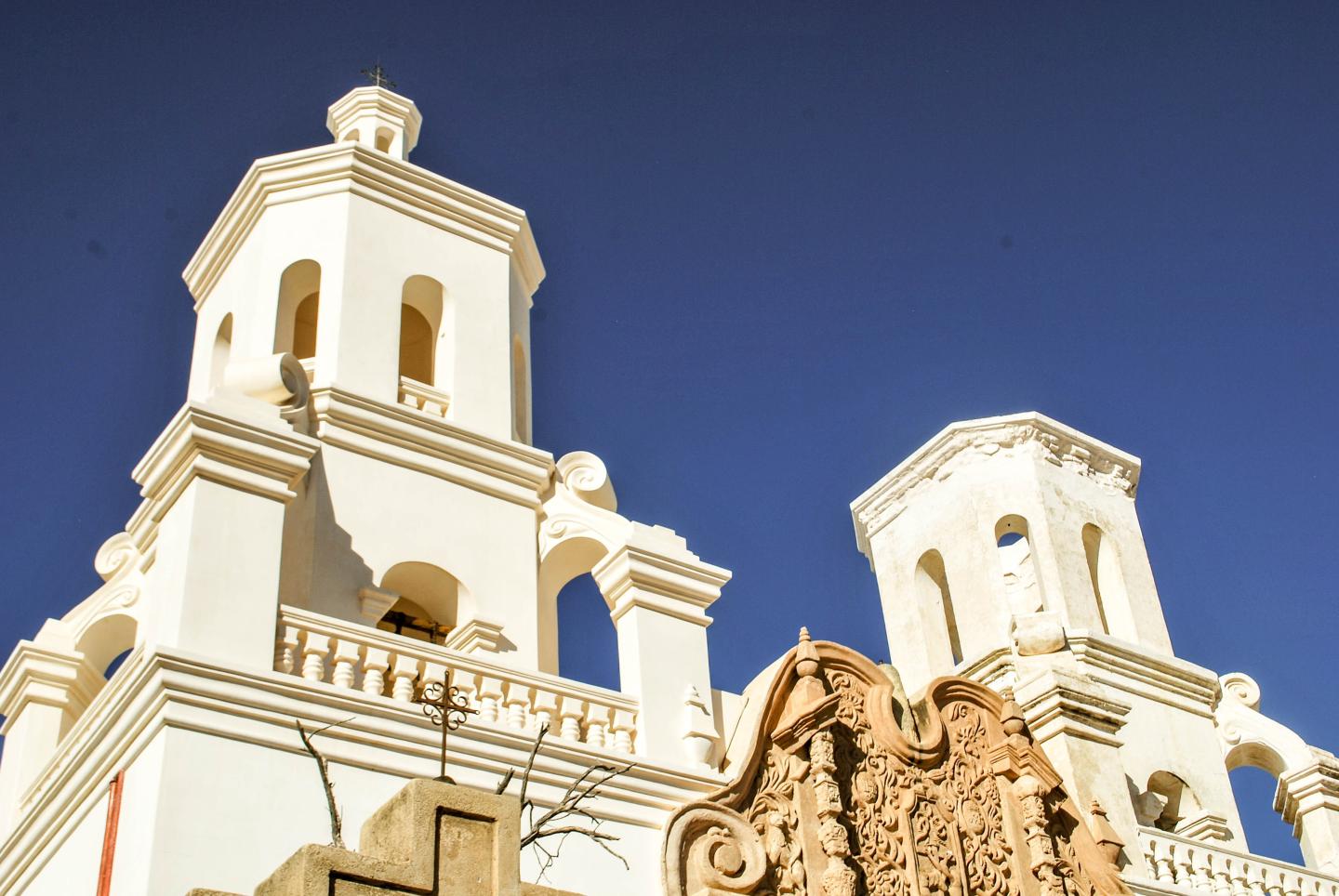 White church towers with ornate details against a clear blue sky.