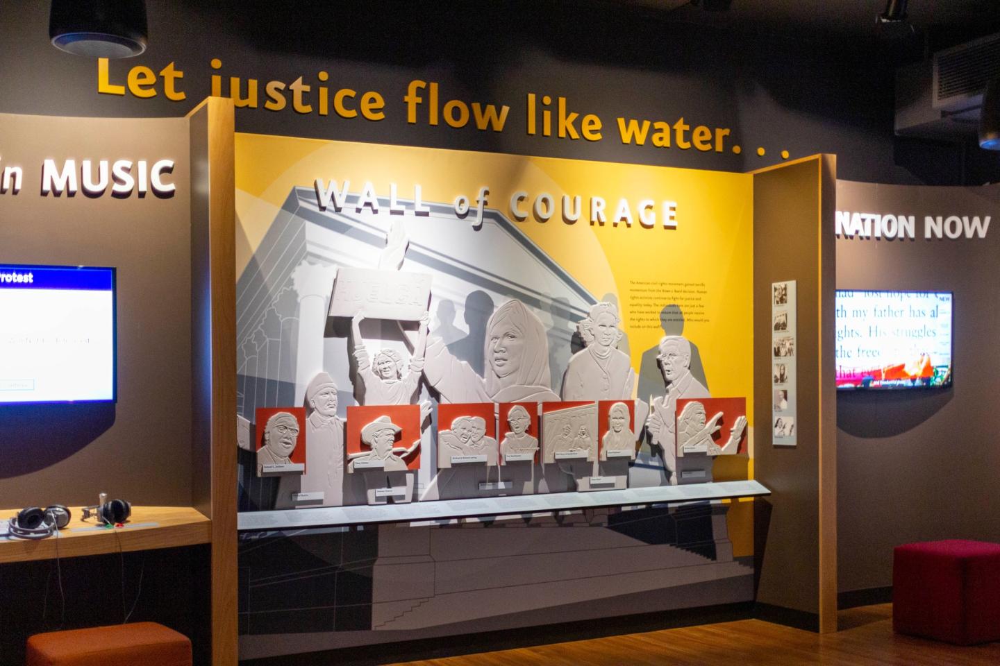 Exhibit with "Wall of Courage" display and illustrated figures.