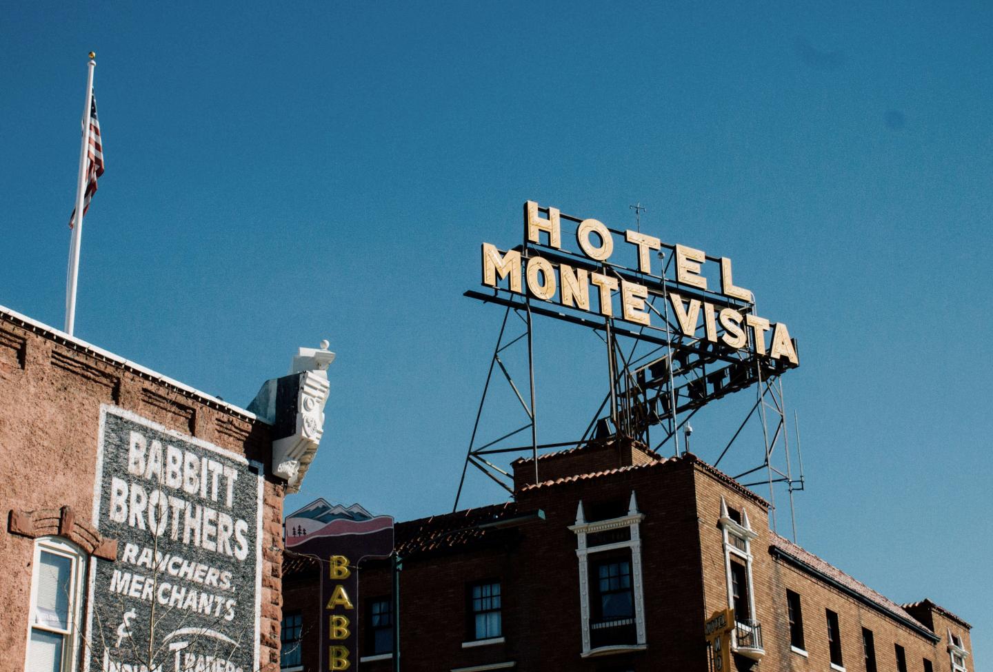 Hotel Monte Vista sign on a brick building under a clear blue sky.
