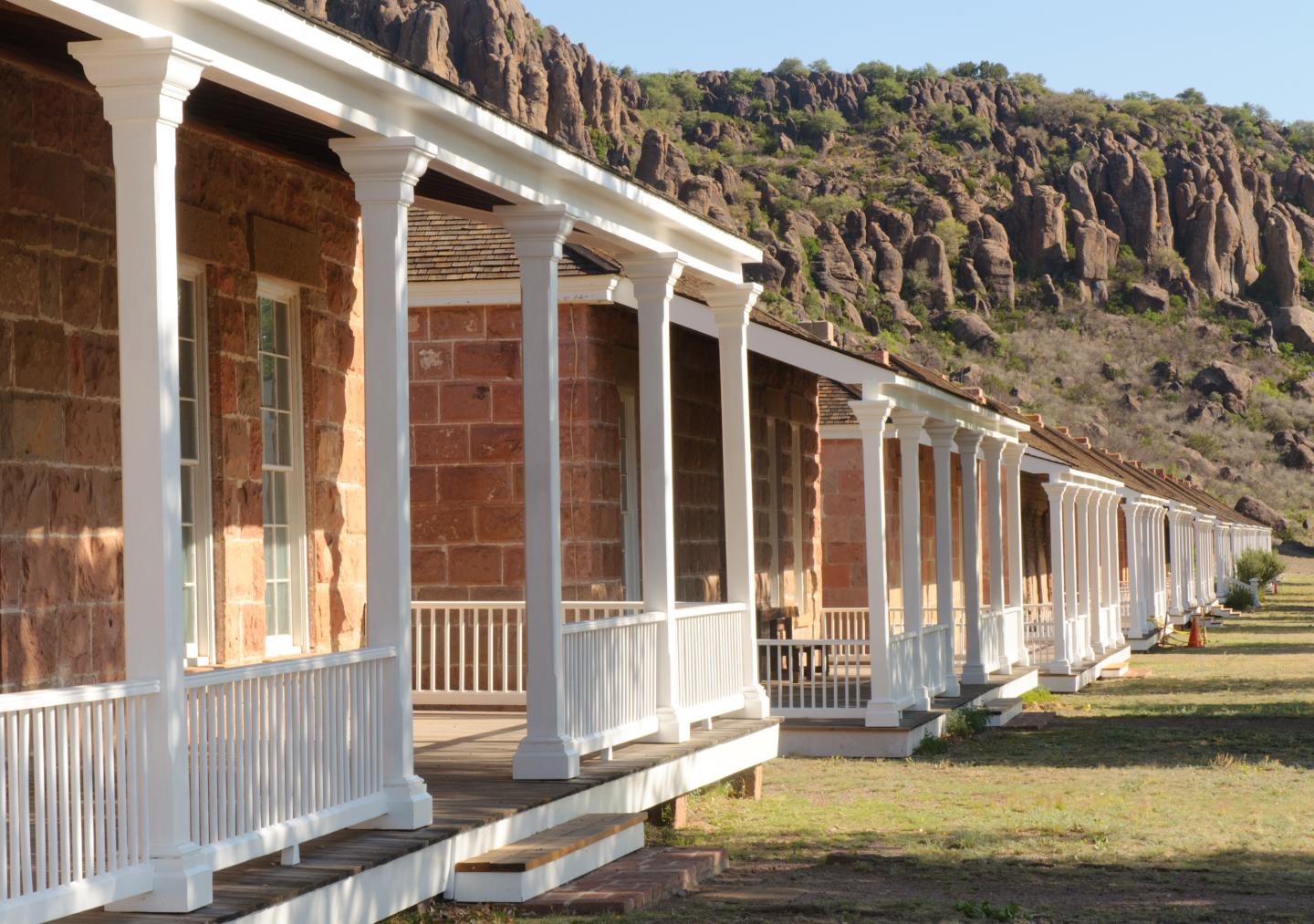 Fort Davis buildings with white porches against a rocky hillside.