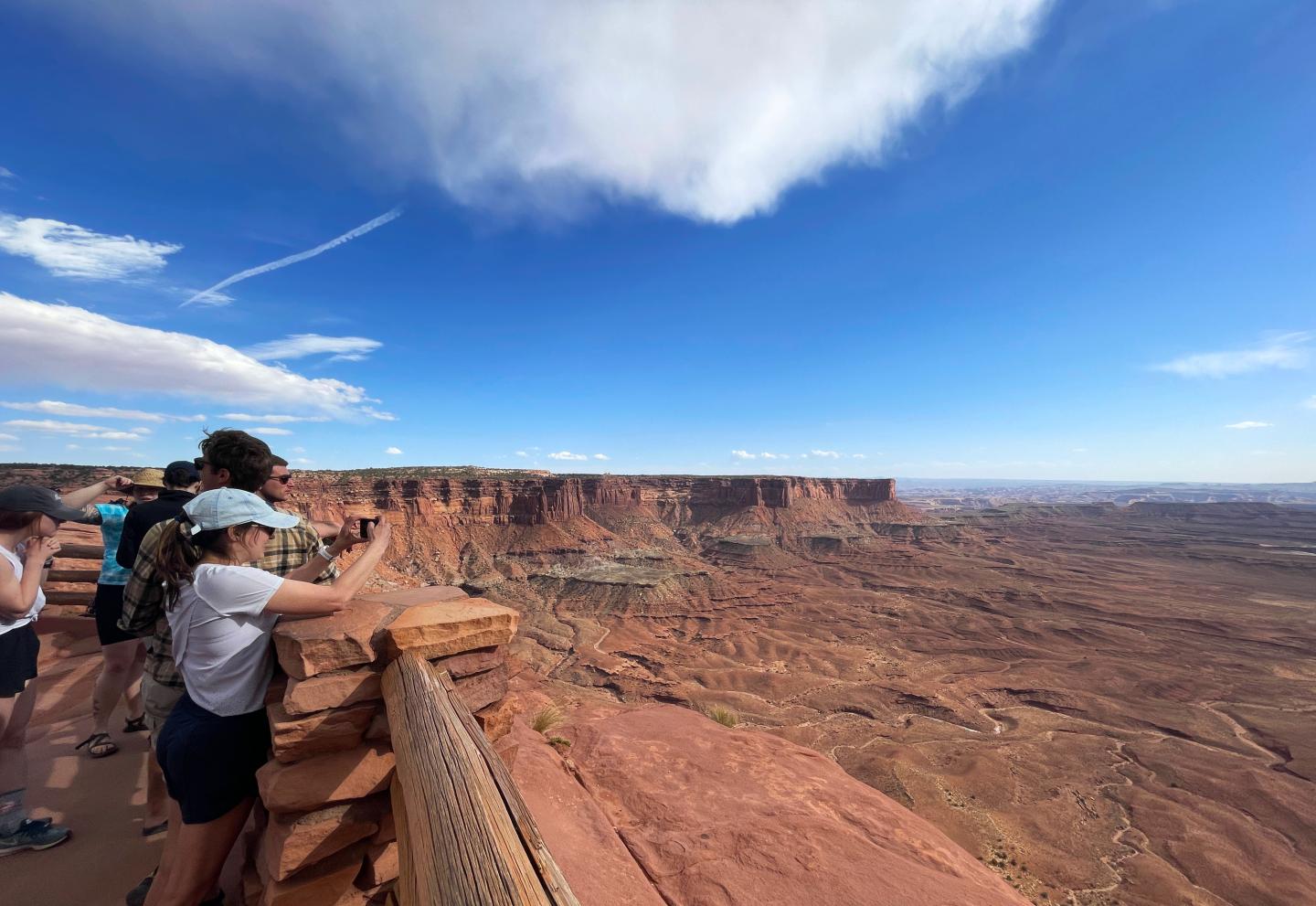 People enjoying the view over Canyonlands under a clear blue sky.