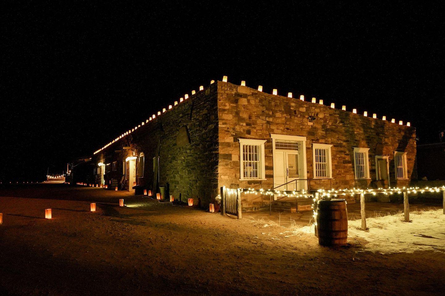 Stone building at night adorned with festive string lights at Hubbell Trading Post