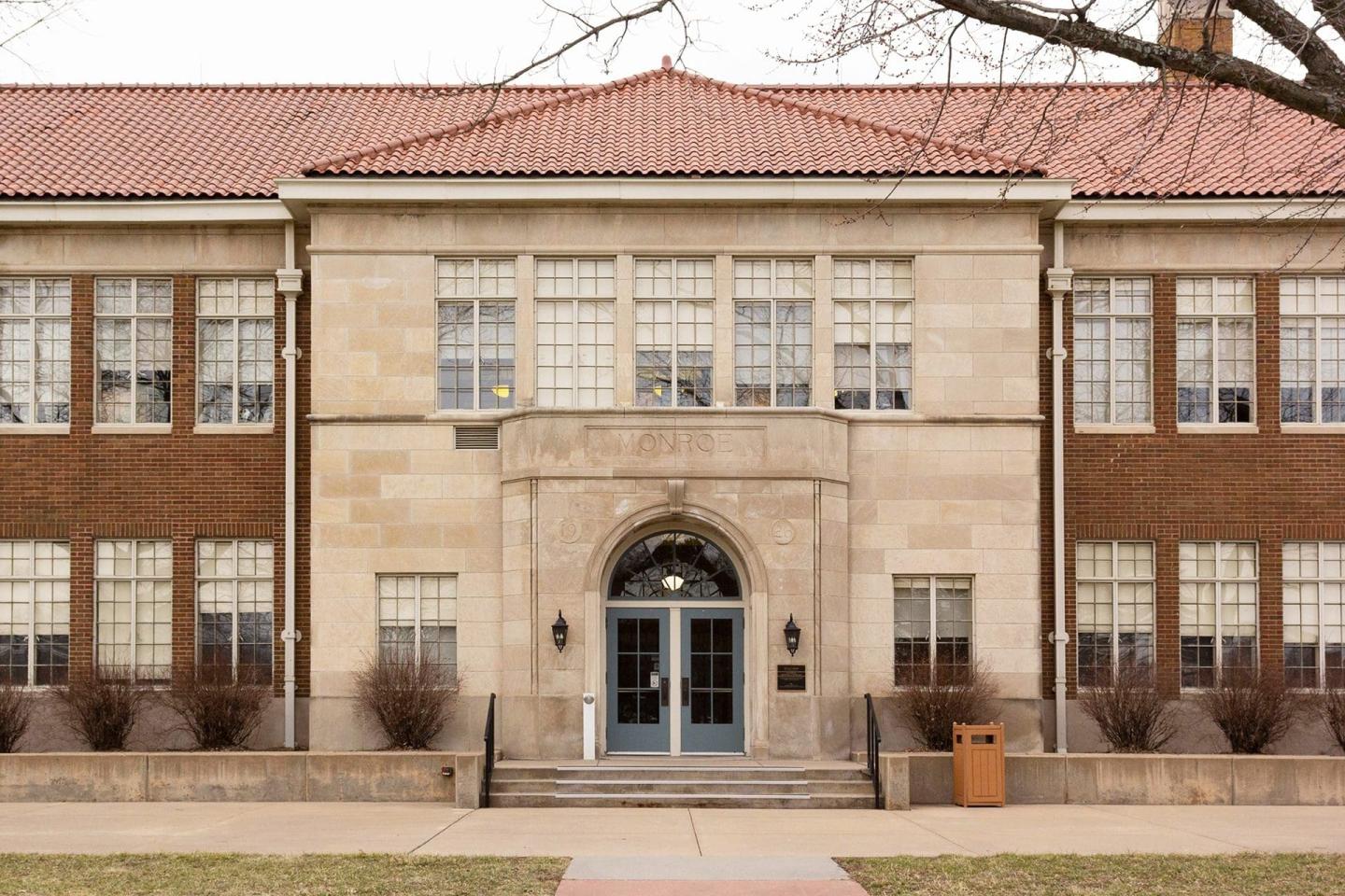 Monroe school with large windows and blue double doors.