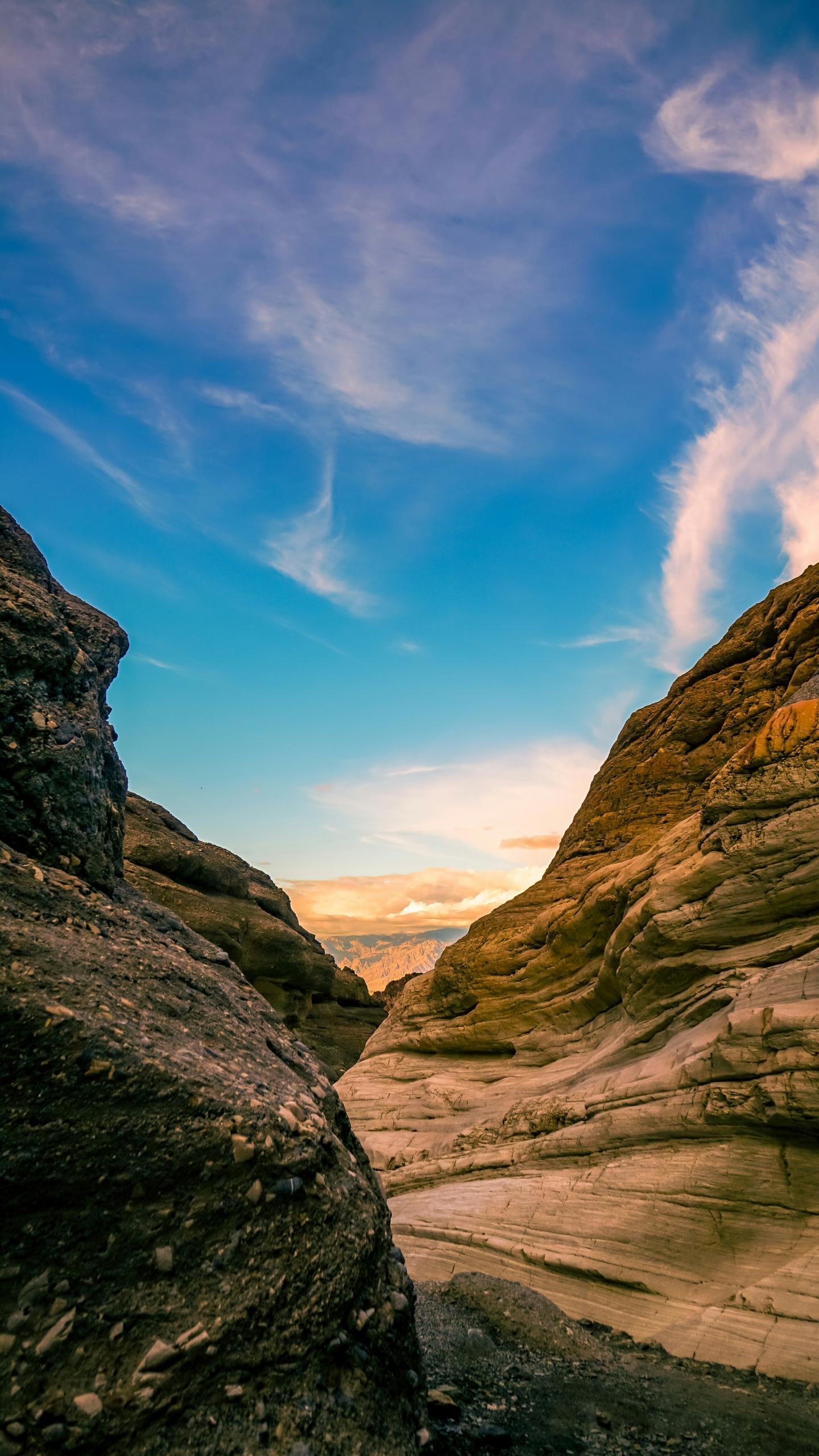 Canyon landscape under a blue sky with clouds.