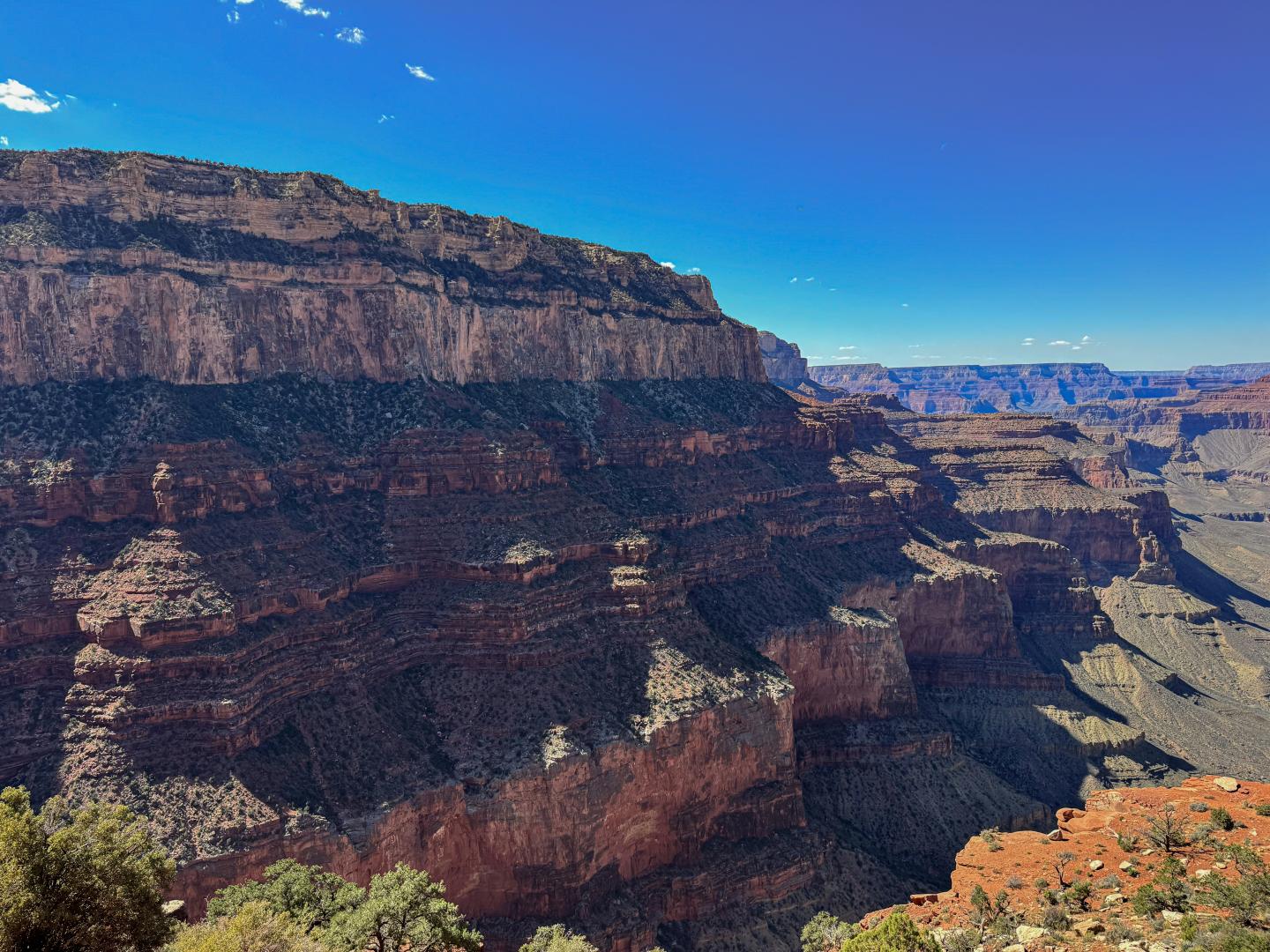 Grand Canyon view with layered rock formations under a clear blue sky.