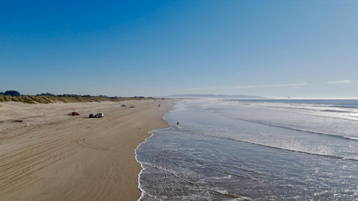 Pismo Beach with gentle waves under a clear blue sky.