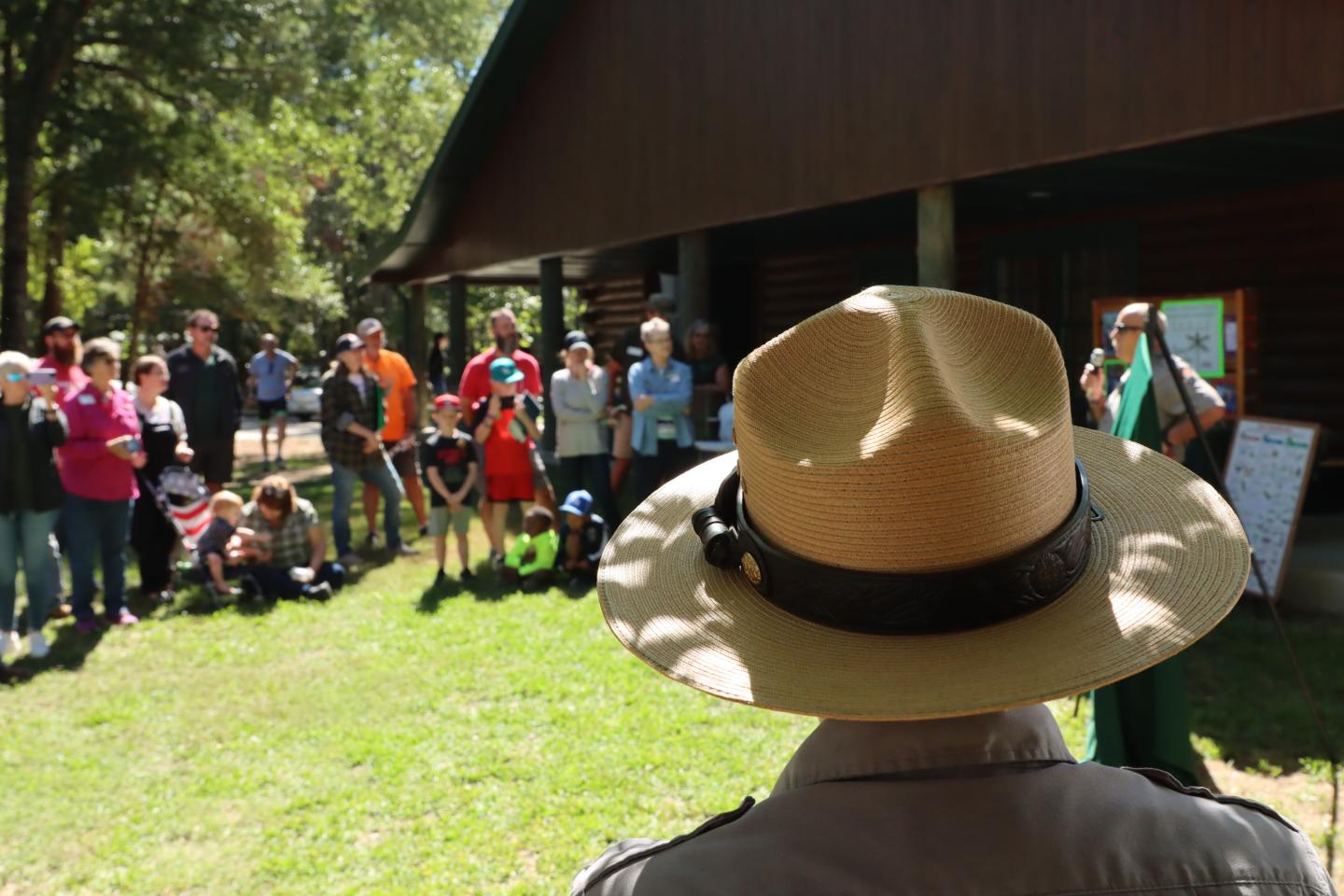 Park ranger addresses crowd outside on a sunny day.