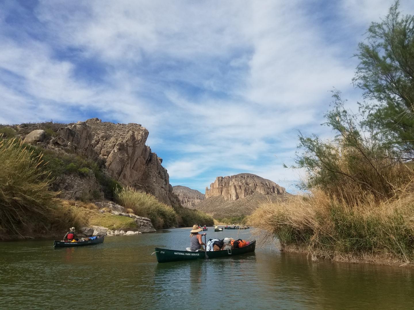 Boats on Big Bend with rocky cliffs and blue sky.