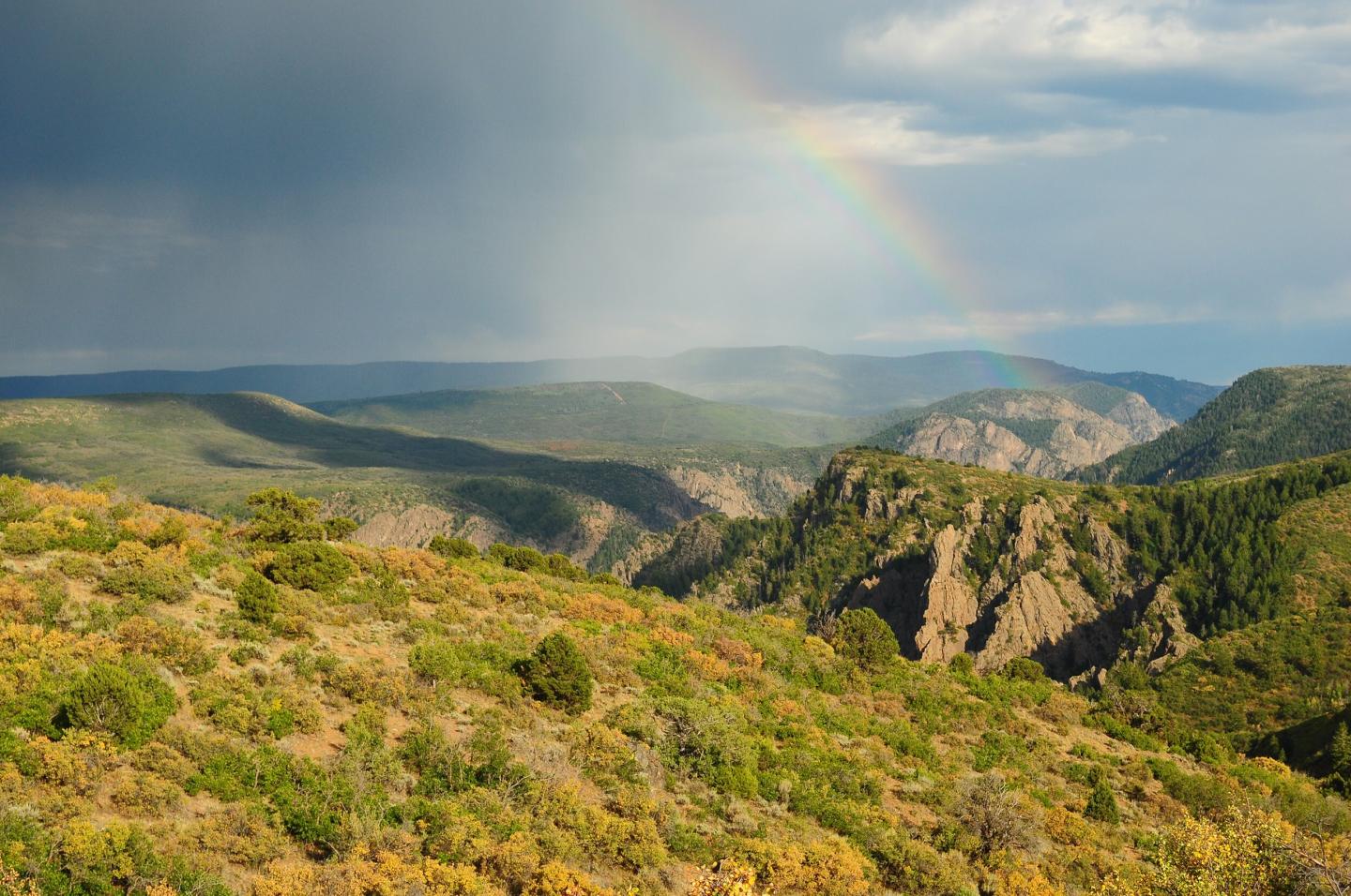 South Rim landscape with a rainbow under a cloudy sky.