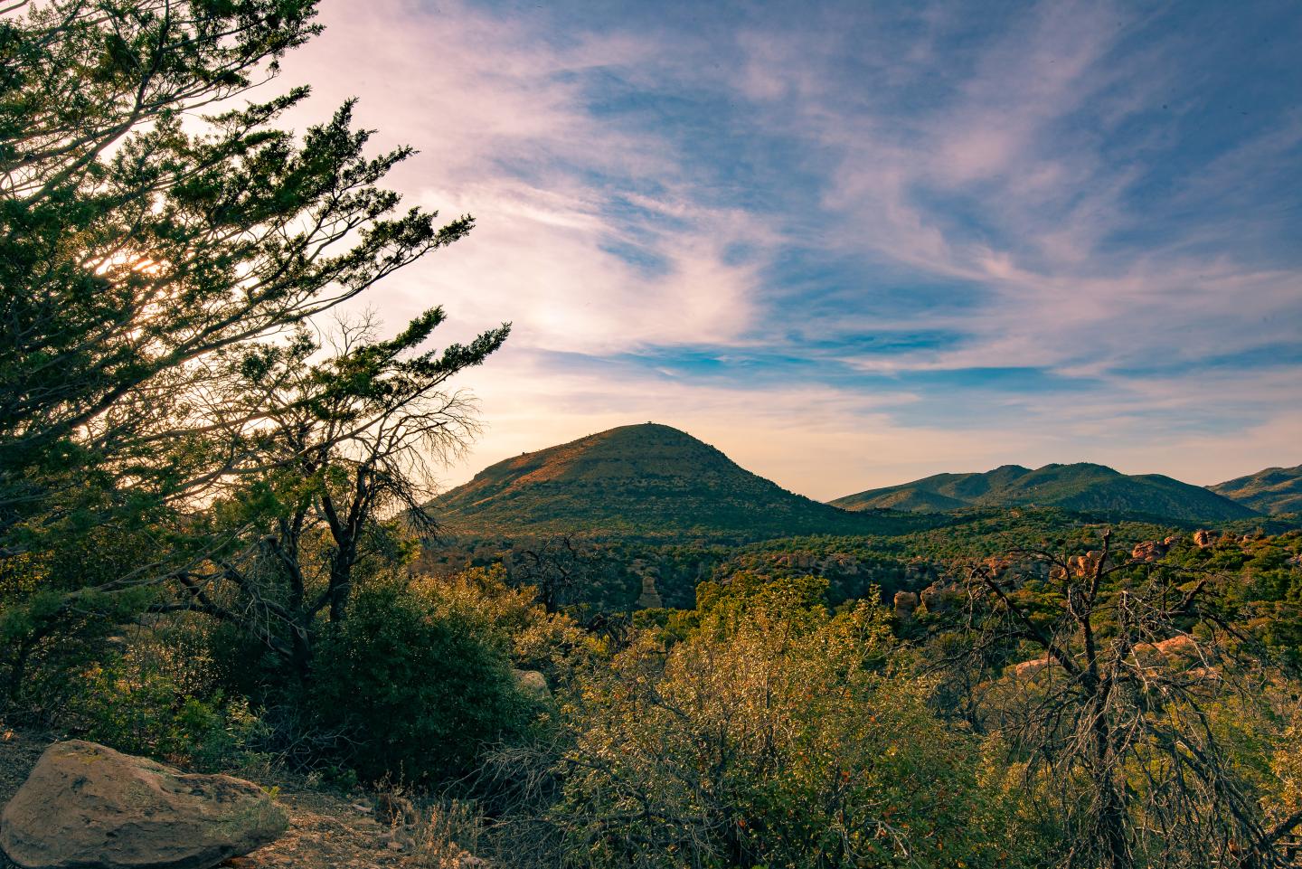 Sugarloaf mountain at sunset with hills and colorful sky.