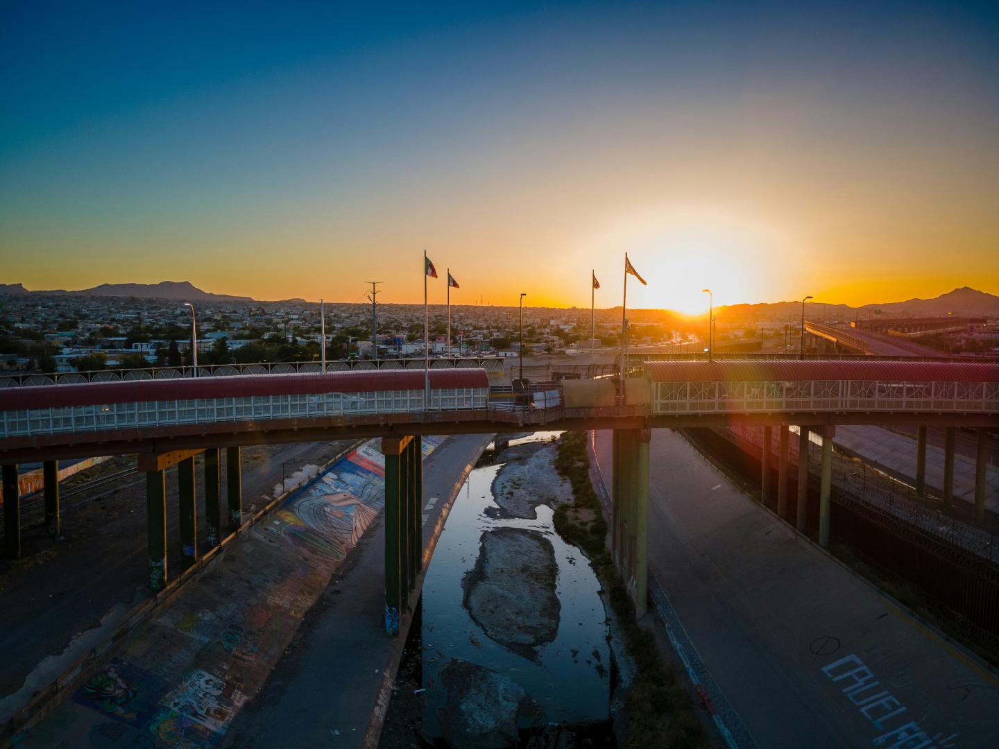 El Paso sunset over a bridge and stream in a cityscape.