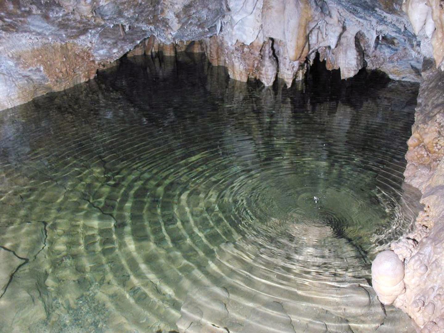 Rippling water in a Timpanogos Cave, stalactites above.