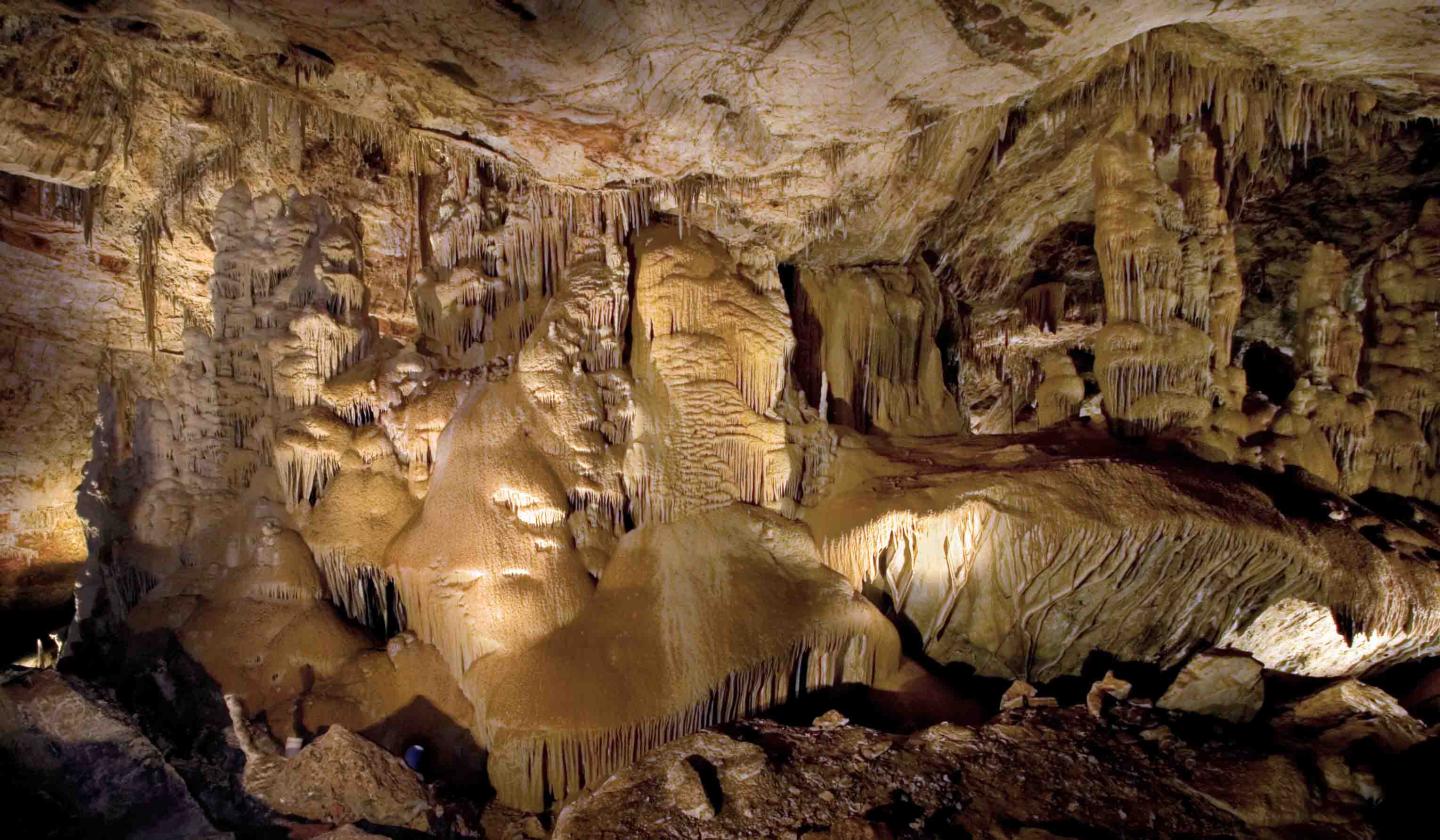 Stalactites and stalagmites in a dimly lit cave interior.
