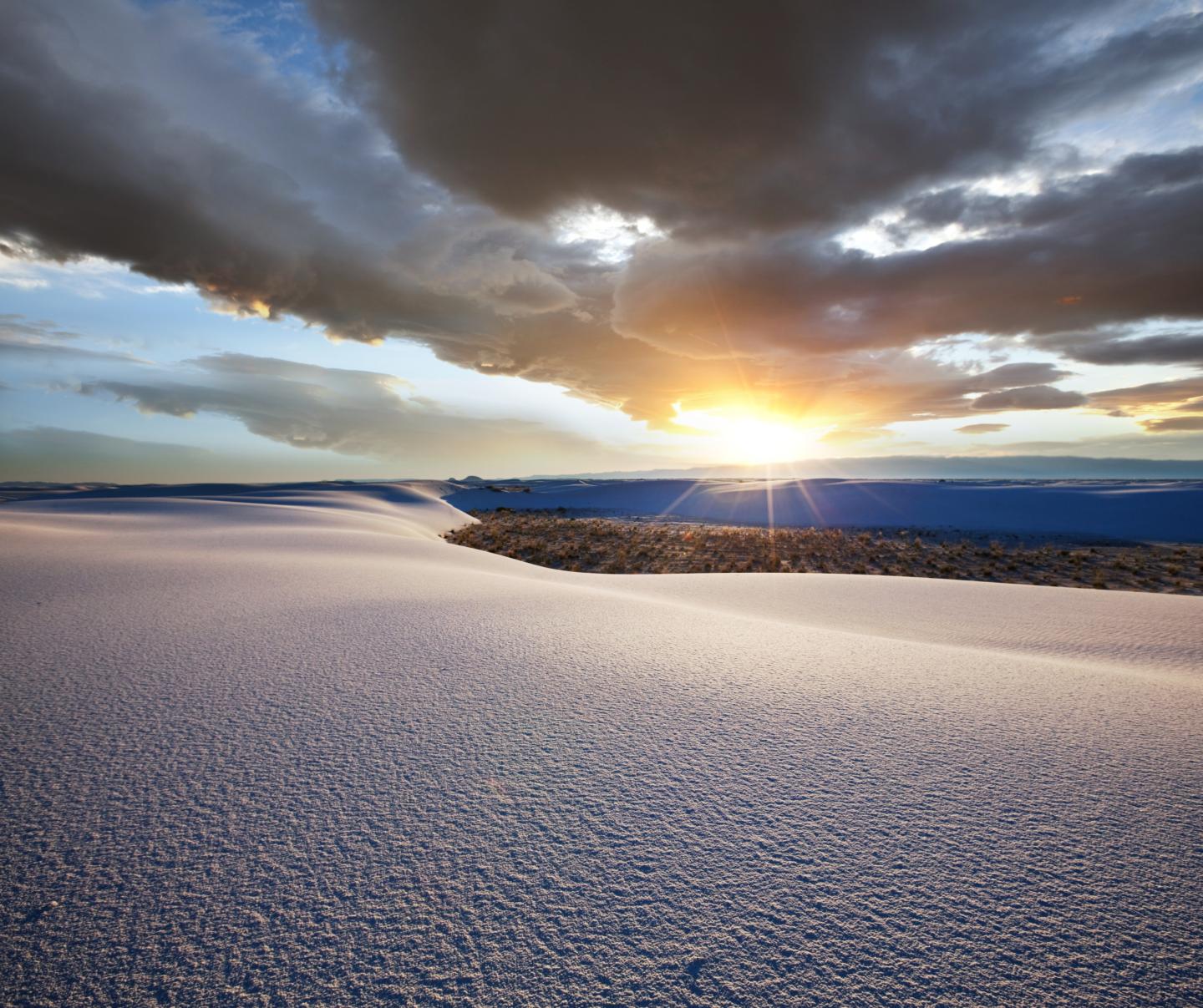 White Sands landscape with a vibrant sunset and cloudy sky.
