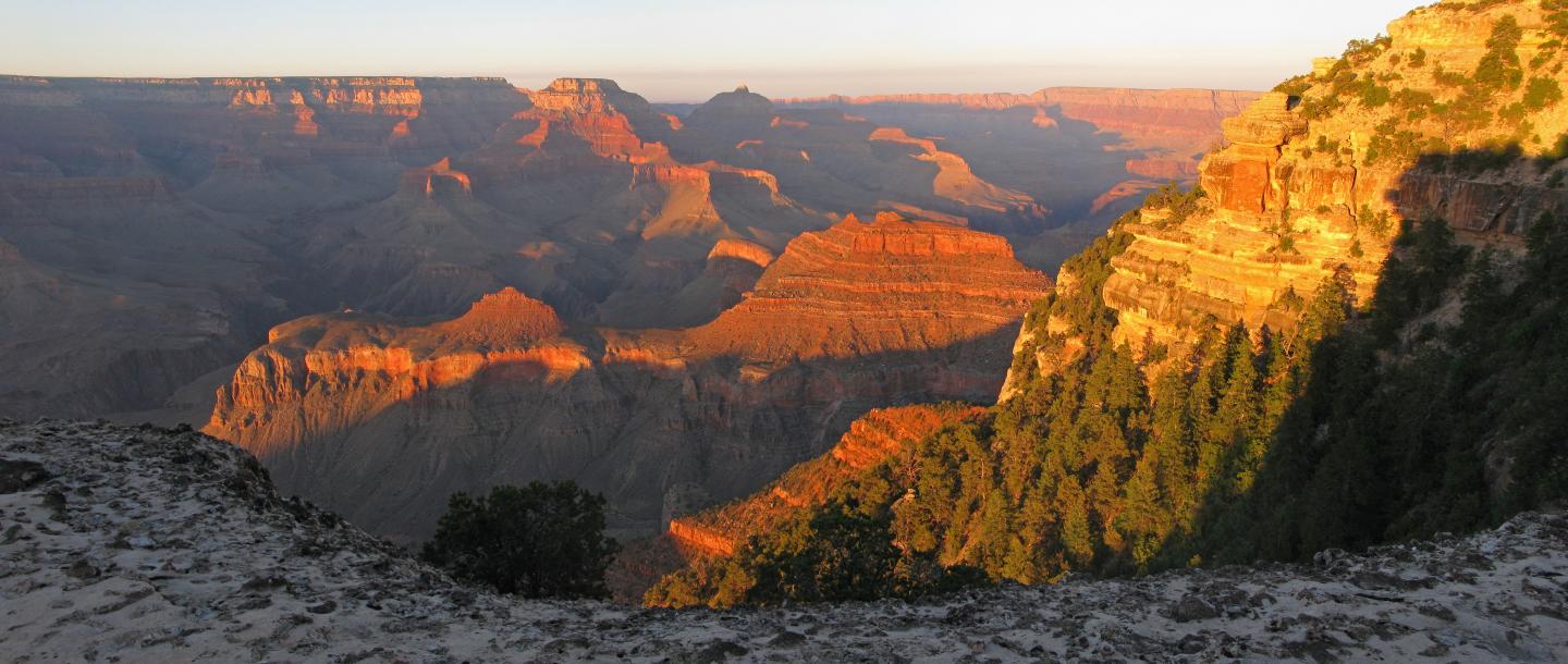 Grand Canyon at sunset, with rugged cliffs and deep shadows.