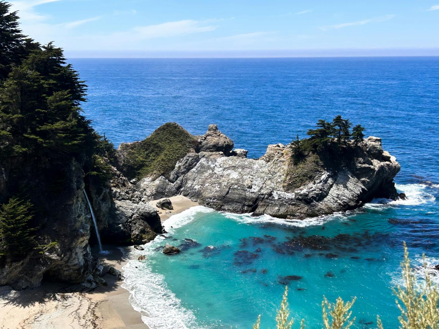 Coastal cliffs and turquoise water under a clear blue sky.
