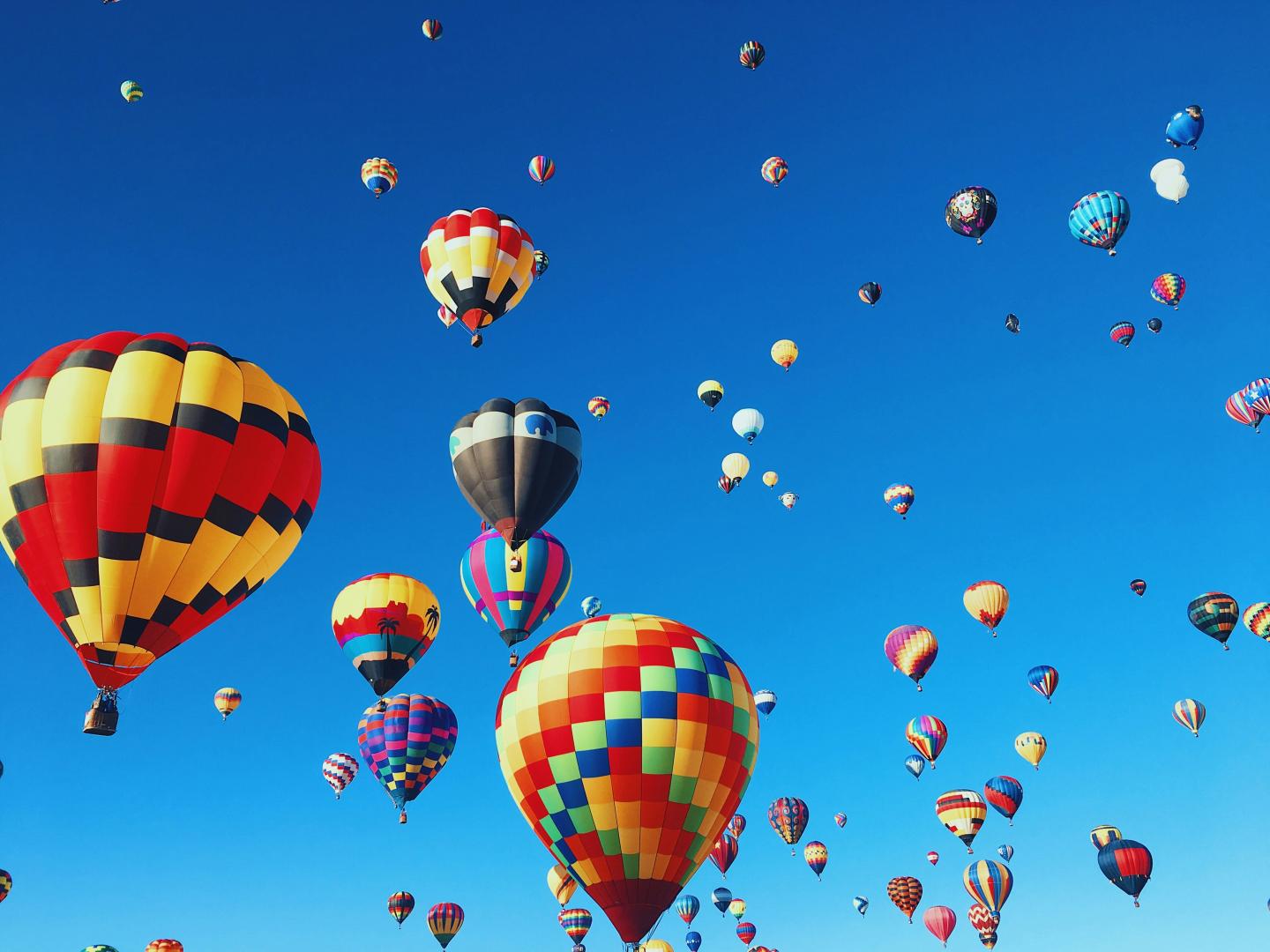 Colorful hot air balloons floating in a clear blue sky.