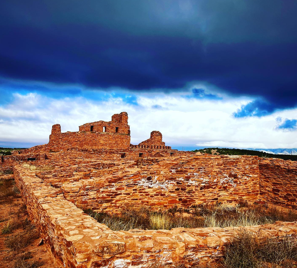 Ancient ruins under a dramatic cloudy sky.