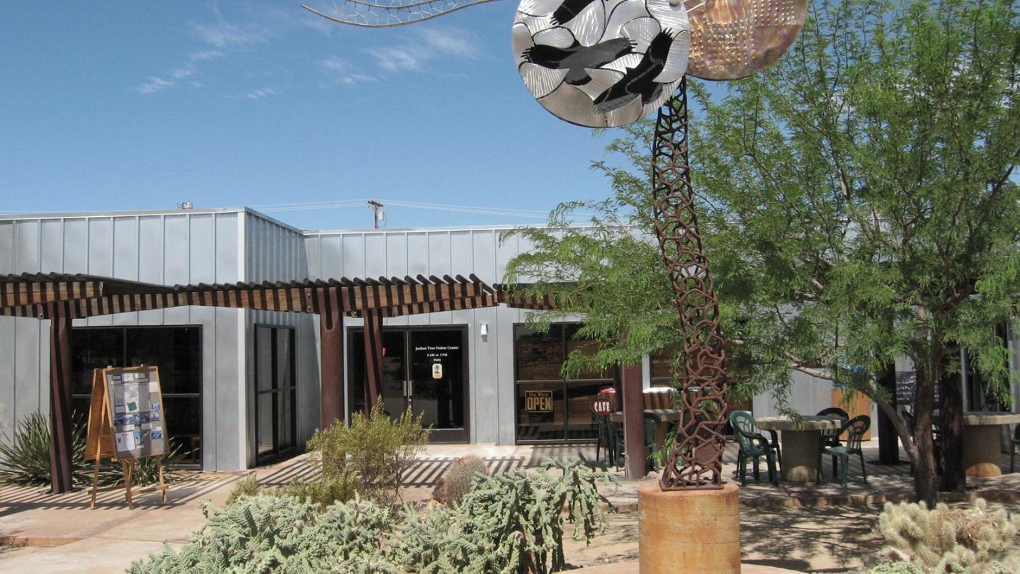 Cottonwood Visitor Center building with metal sculpture in desert landscape.