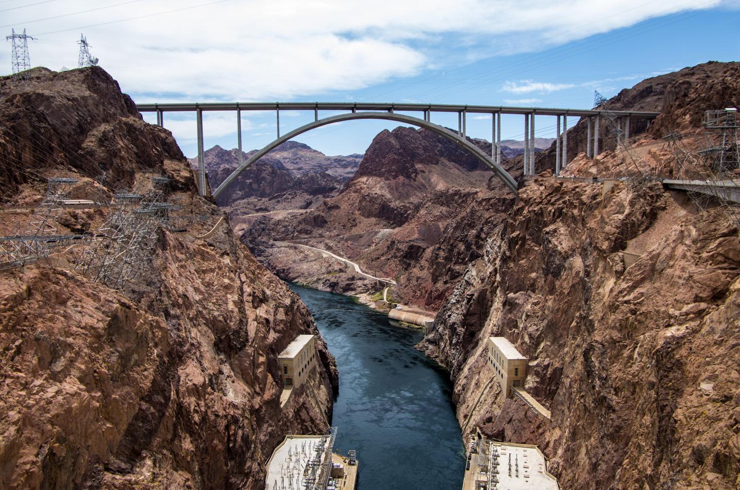 Hoover Dam Bridge spans across rocky canyon with river below.