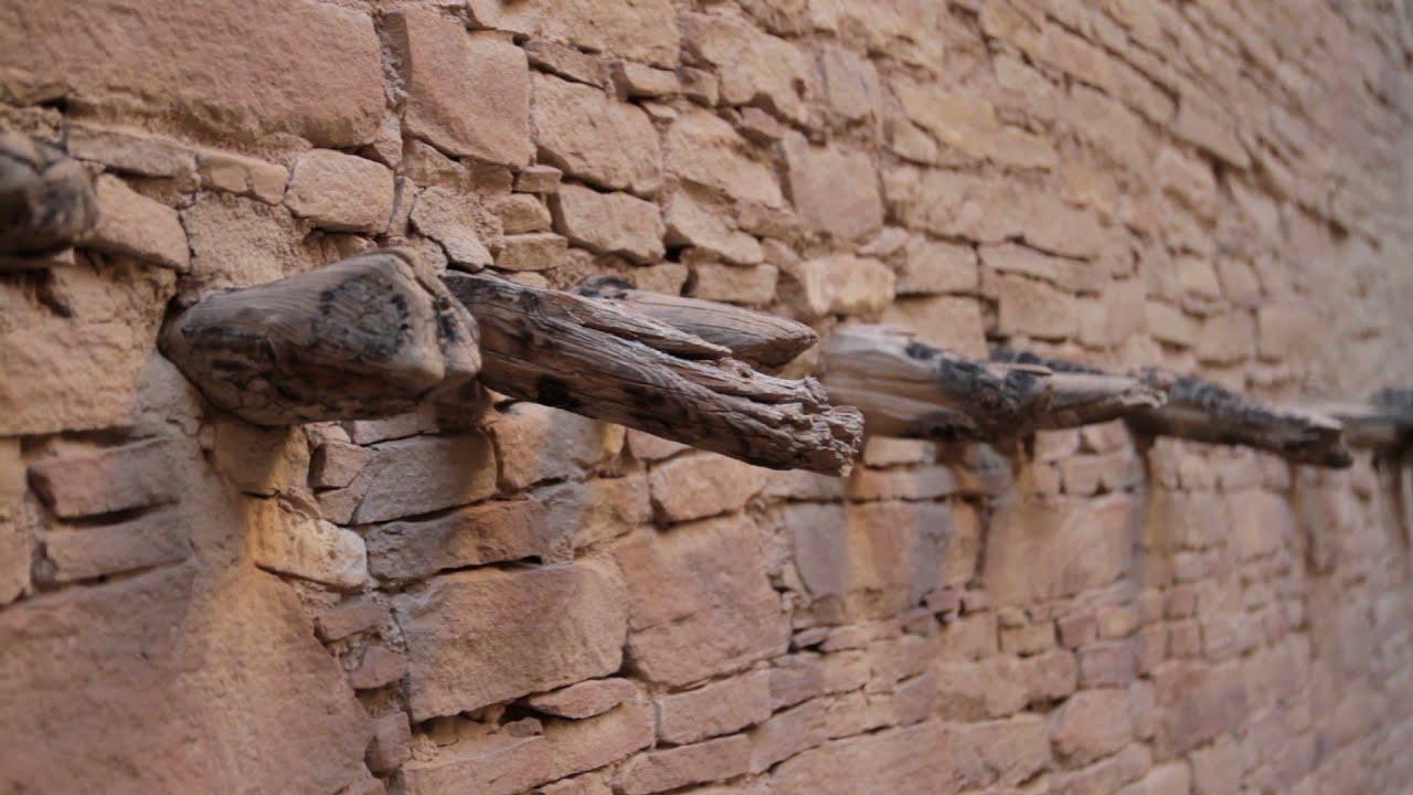 Stone wall with protruding wooden beams.