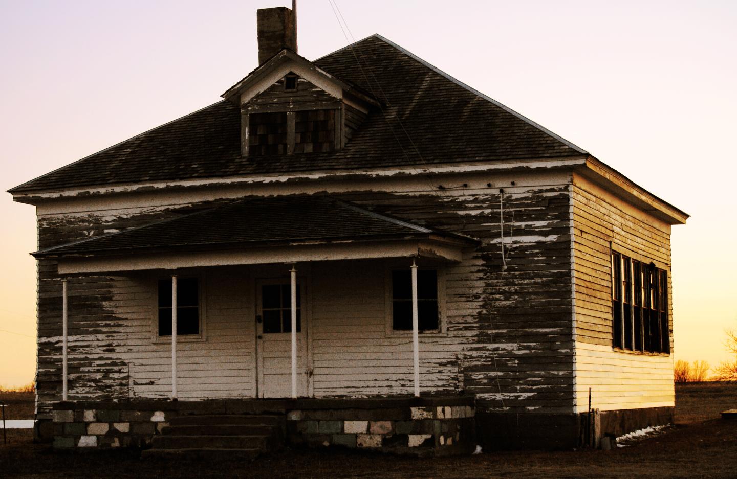 Nicodemus house with peeling paint at sunset.
