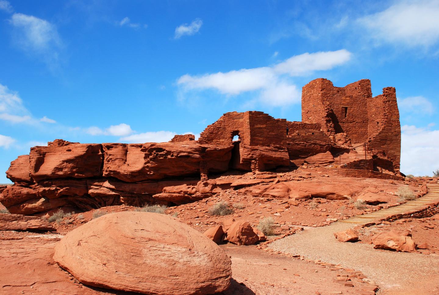 Ancient red sandstone ruins under a bright blue sky.