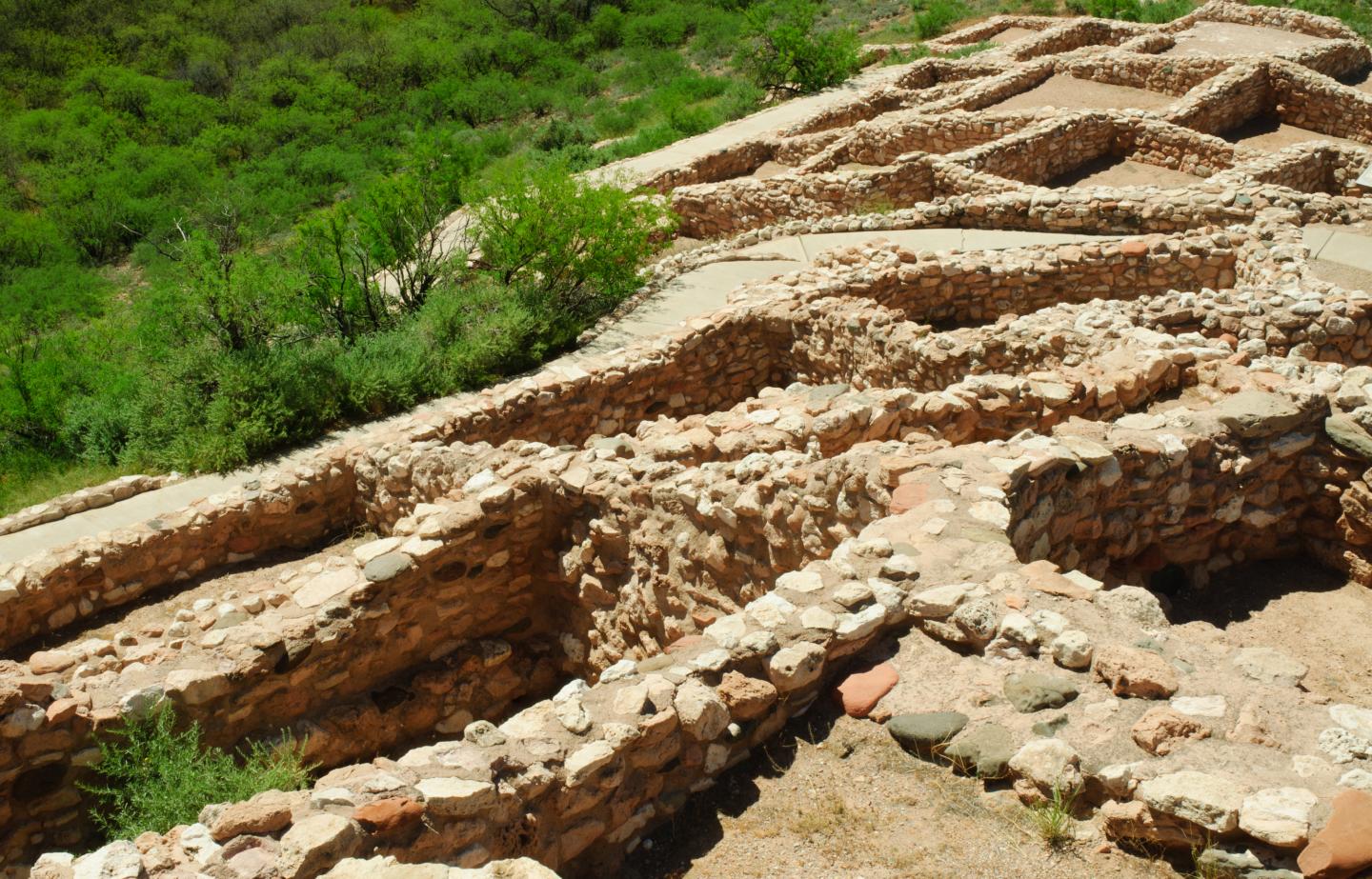 Ancient stone ruins with green foliage in the background.
