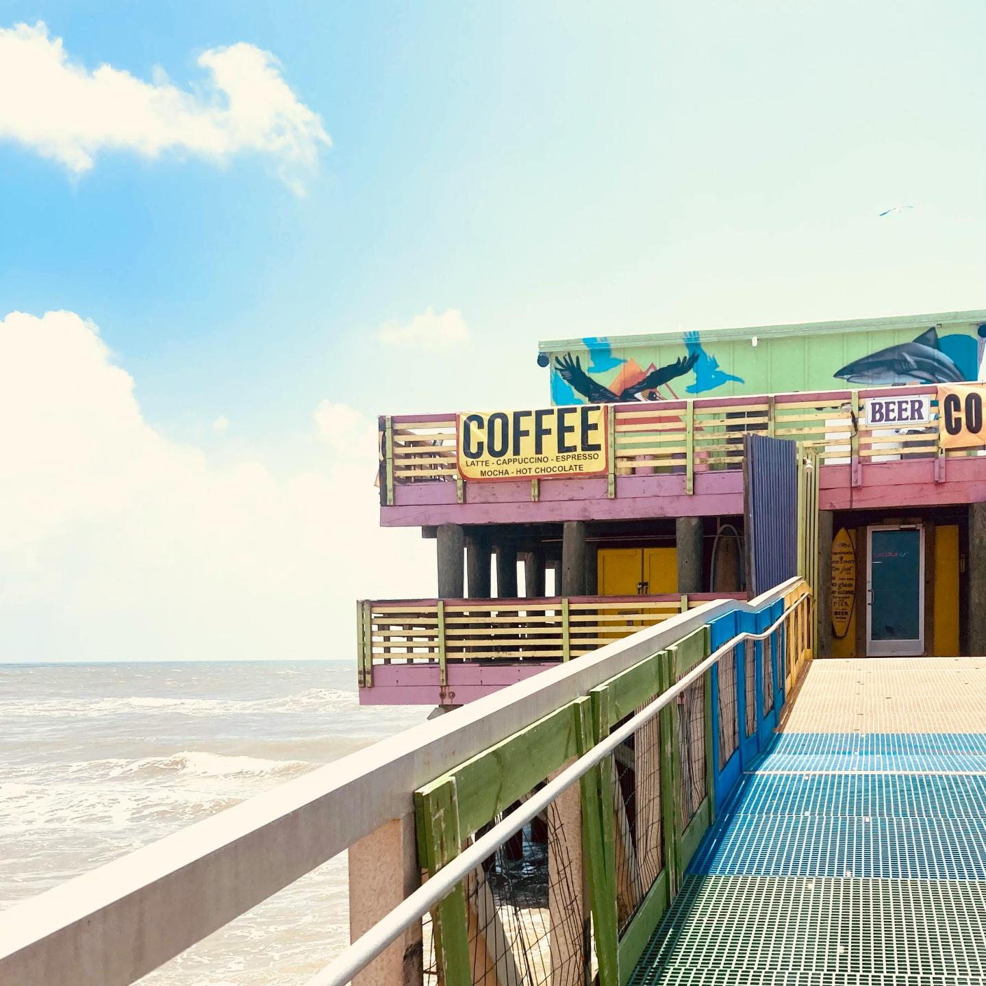 Beachside café with colorful murals on a sunny day.