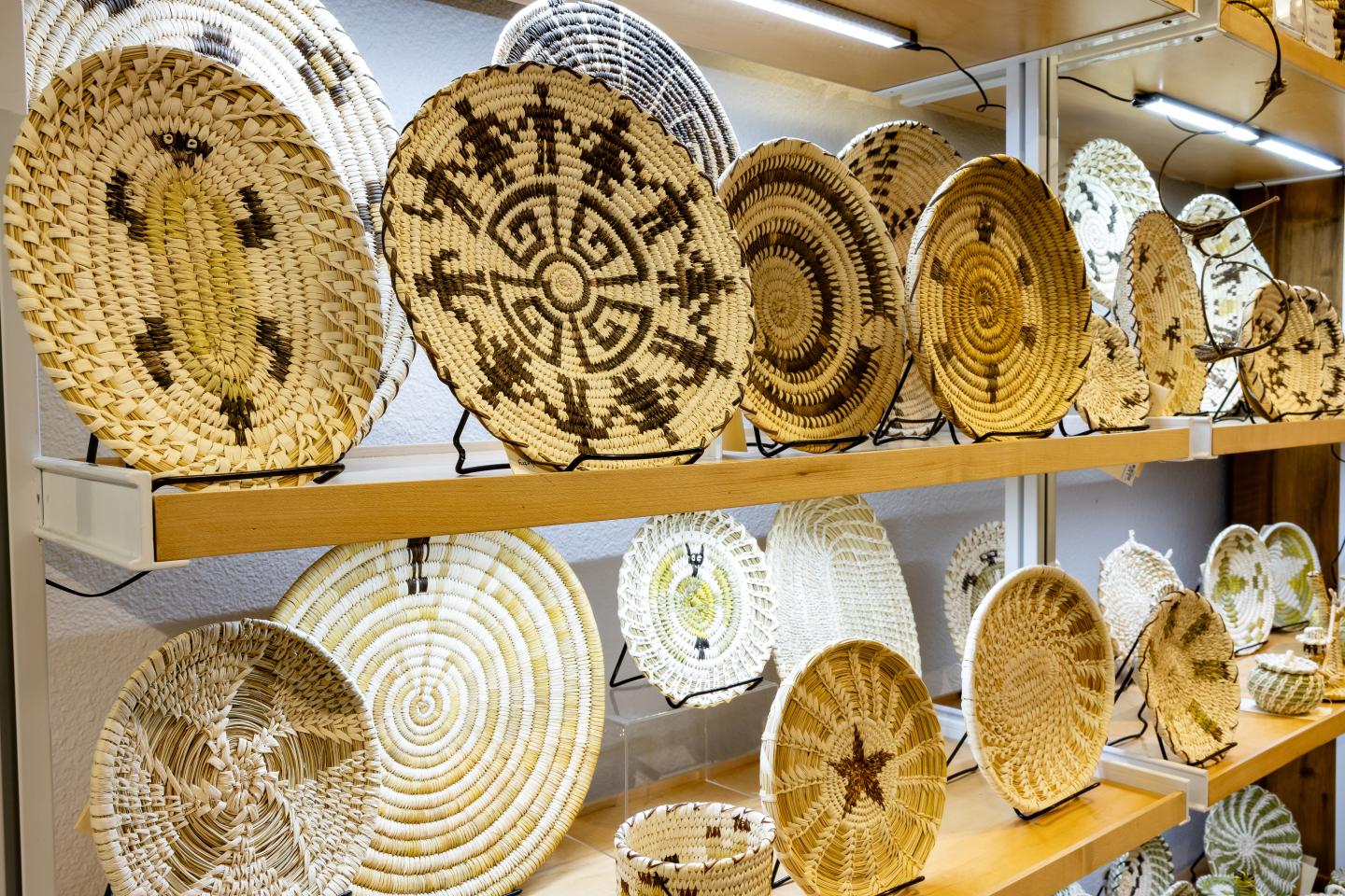 Woven baskets with intricate patterns displayed on shelves.
