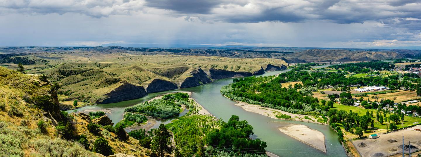 River meandering through a green valley under a cloudy sky.
