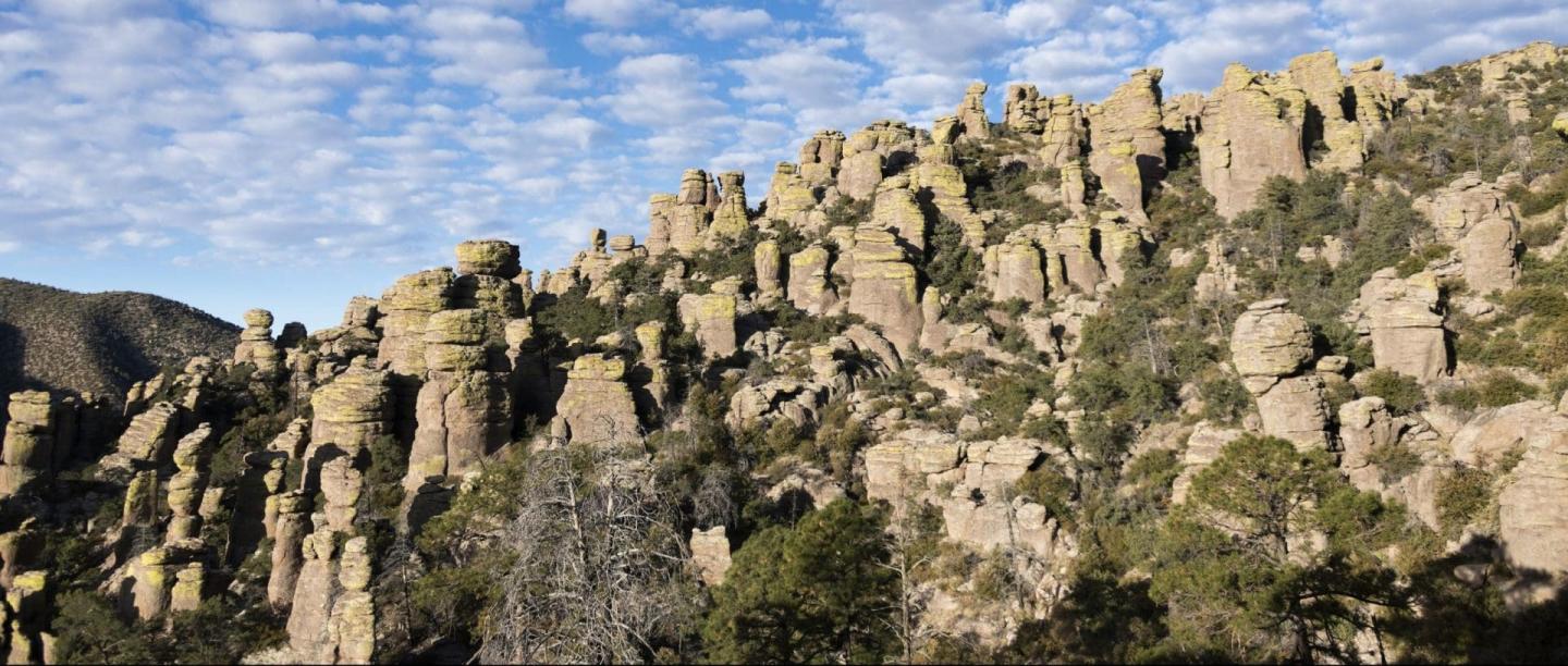 Rocky landscape with towering spire formations under a blue sky.