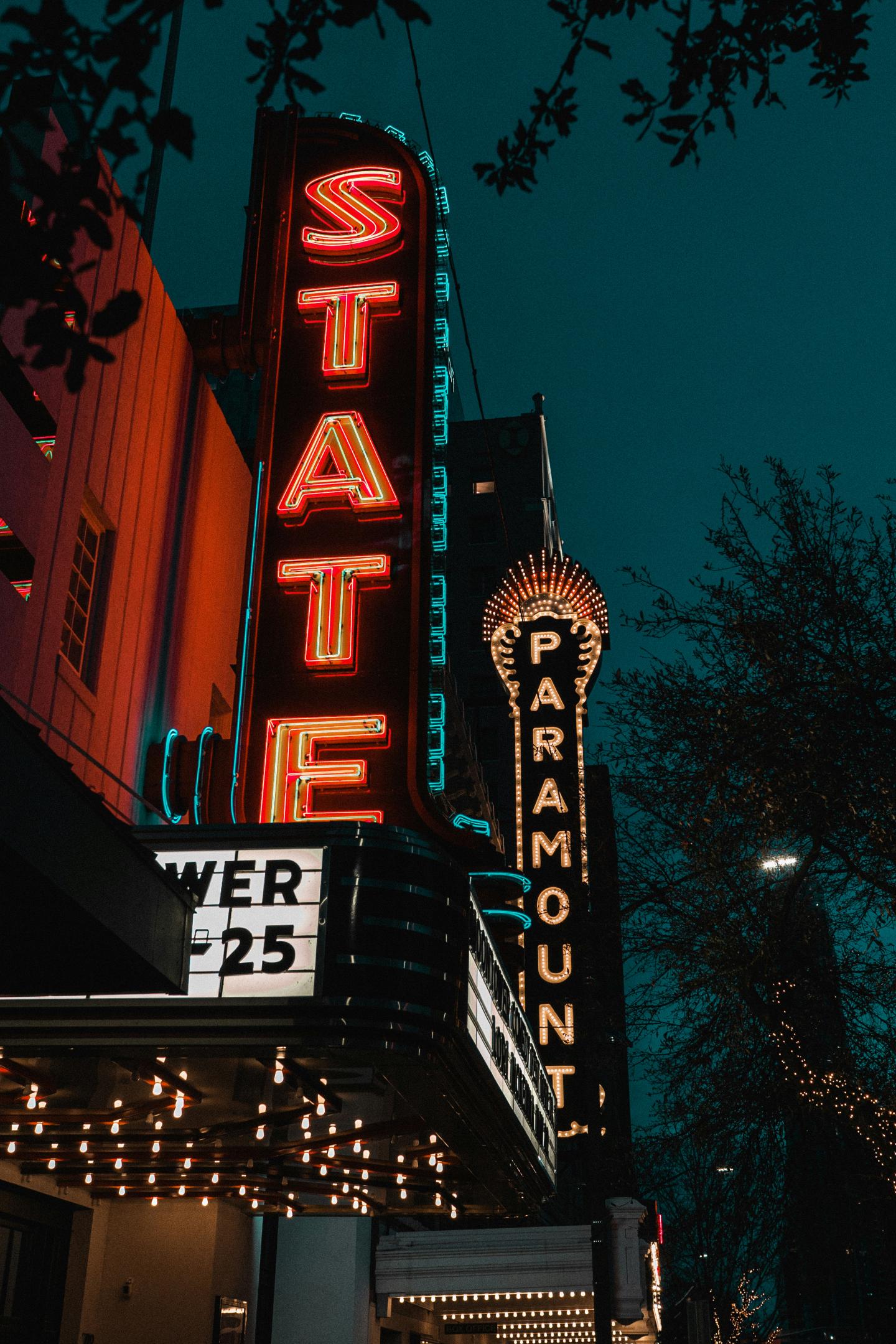 State and Paramount theater signs glowing at night against a dark sky.