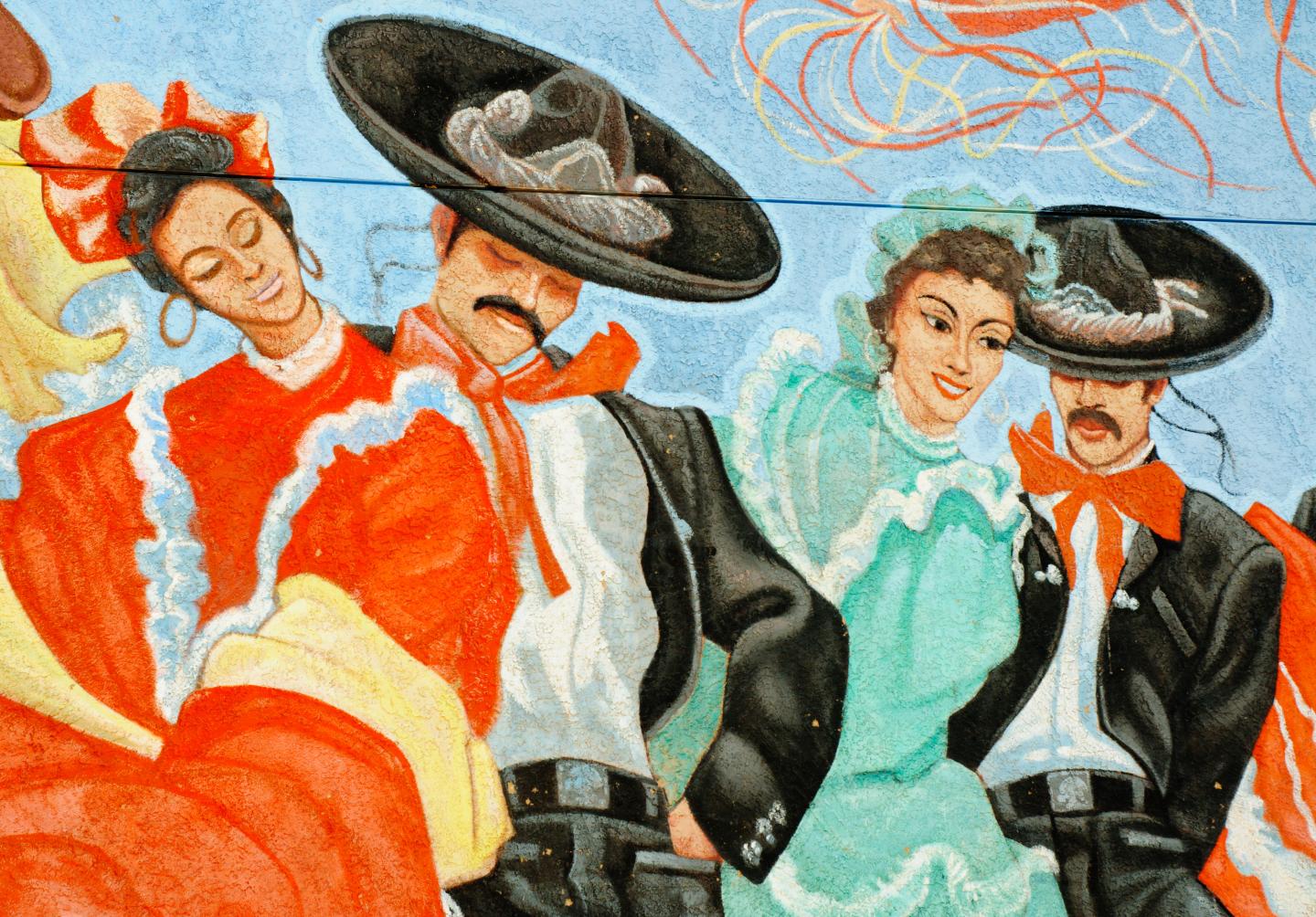 Colorful mural of dancers in traditional Mexican attire with sombreros.