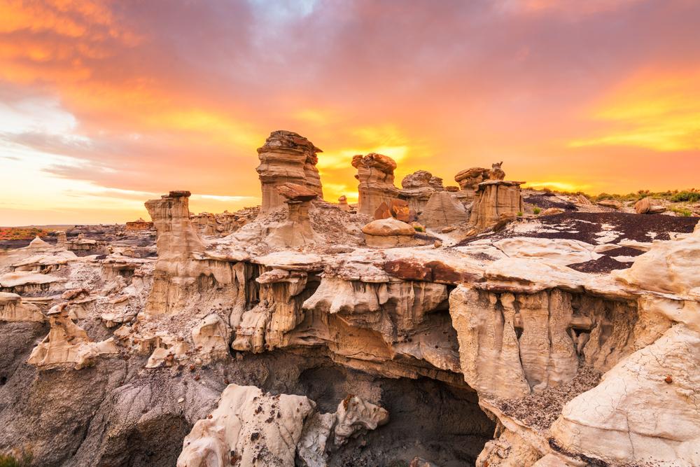 Rocky canyon at sunset, vibrant orange and purple sky.