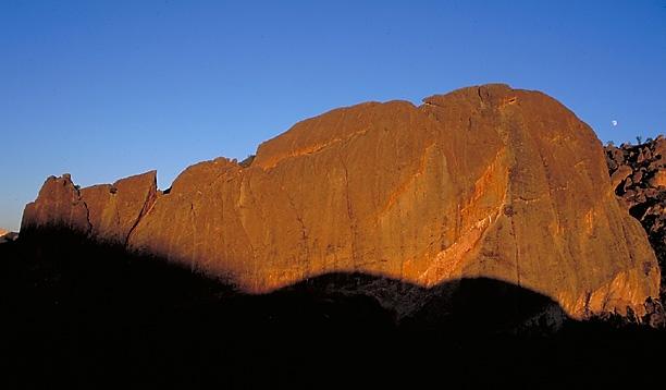 Machete Ridge, a rocky cliff bathed in orange sunlight under a clear blue sky.